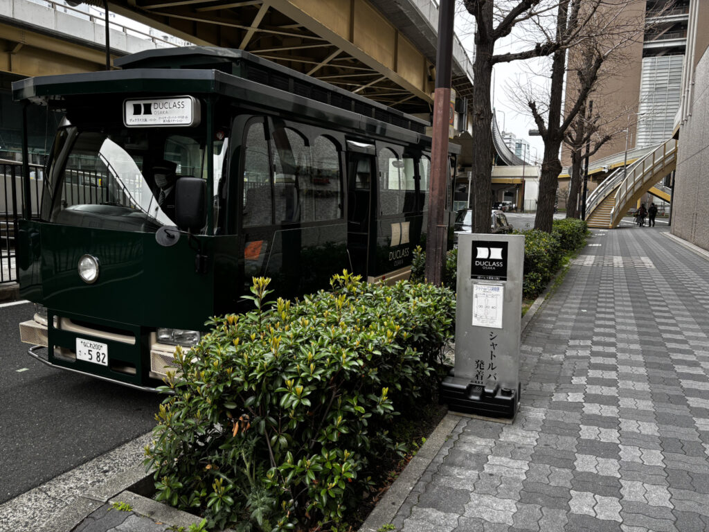 新大阪駅2番出口すぐ、コートヤード・バイ・マリオット新大阪ステーション前に停車中のデュクラス大阪専用シャトルバス